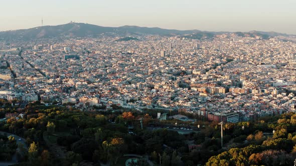 Panoramic Aerial View of Barcelona Cityscape and Cableway on Montjuic Hill Covered By Green Trees alt