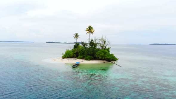 Aerial: flying over desert island tropical beach caribbean sea coral reef sunset alt