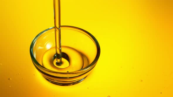 Super Slow Motion Shot of Pouring Golden Oil Liquid Into Glass Bowl at 1000Fps alt