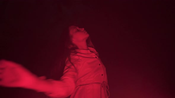 Slow ecstatic dance of young woman in darkness red light night club party meditative music freedom alt
