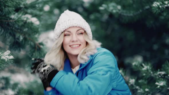 Happy Woman Having Fun and Playing Snowballs on Winter Forest Background alt