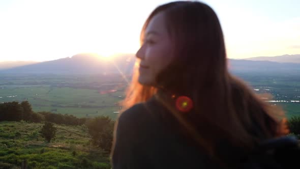 Slow motion of a young woman watching sunset and mountain views in the evening