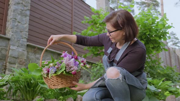 Woman Gardener Florist in Garden with Basket of Fresh Plucked Garden Spring Flowers alt