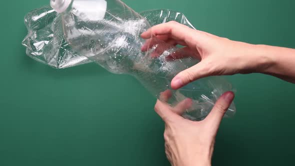 POV Female Hands Crushing Plastic Bottle for Recycling