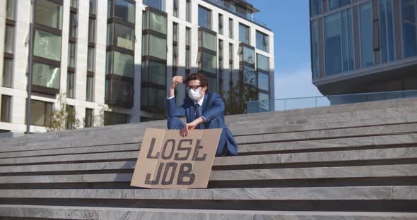 Unemployed Businessman in Medical Mask Sitting on Stairs Outdoor Holding Poster Lost Job alt