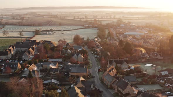 Aerial drone video of a Cotswold Village, a rural scene in English countryside with houses, property alt
