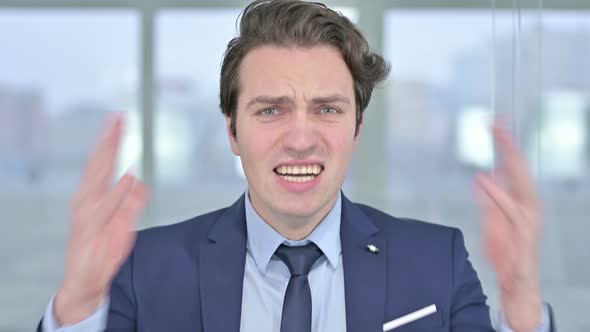 Portrait of Angry Young Businessman Shouting alt