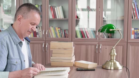 Senior Man with Mustache Reading a Book alt