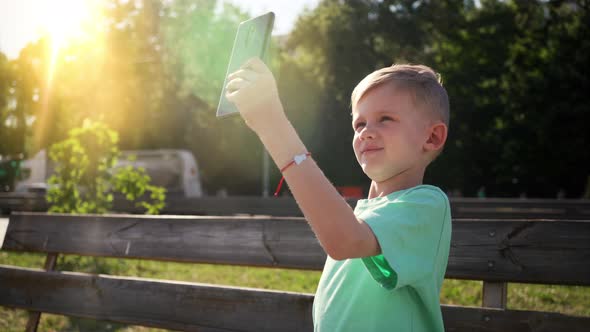 Young Teenager Taking Selfie Photo with His Smartphone in Garden alt