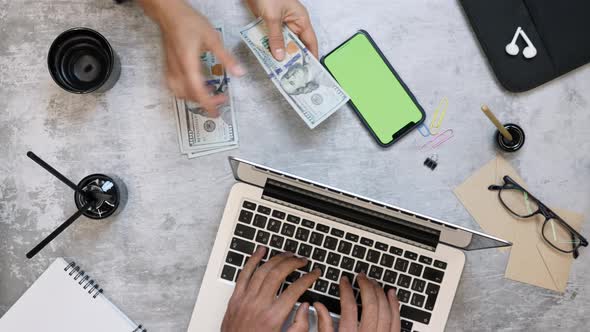 Woman counting dollar bills money, man working on laptop computer alt