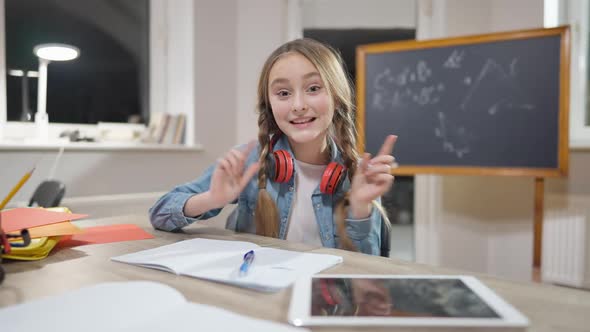 Portrait of Cute Caucasian Girl Blogger Talking and Gesturing Sitting at Desk alt