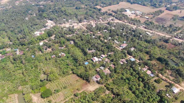 Aerial view of Battambang Cambodia on a clear dry summer day showing trees houses and empty fields alt