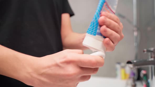 Men's Hands Squeeze a Face Wash From a Tube Into Their Palms alt