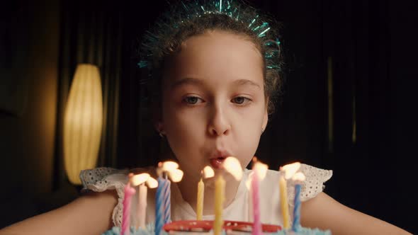 Child Blowing Out Candles on Cake alt