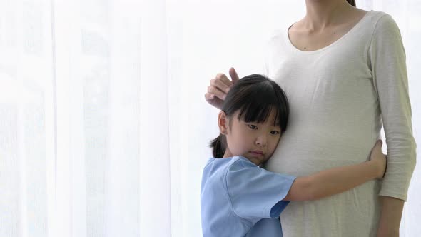Daughter hug and listening sound flex in pregnant mother belly alt
