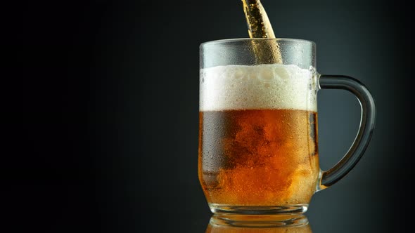 Super Slow Motion Shot of Pouring Fresh Beer Into Glass on Black Background at 1000Fps. alt