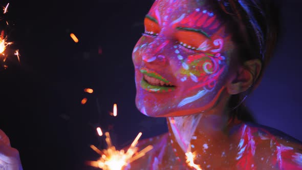 Woman with UV Drawings with Sparklers Under the Light of Fluorescent Lamps alt