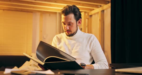 Portrait of a Bearded Middle Aged Caucasian Male Photographer in a Wheelchair Viewing an Album alt