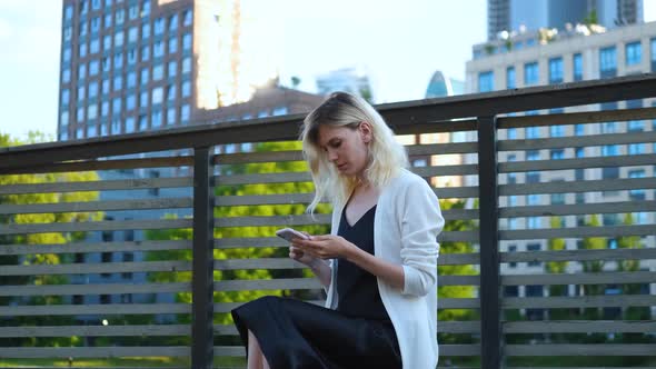 woman with a phone on the background of a big city