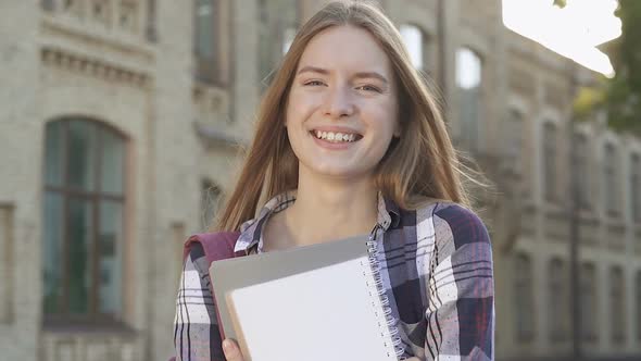 Pretty Student Girl Standing Neat the University, Smiling and Looking at The Camera