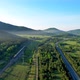 Railway tracks and a highway in the middle of the forest and mountains. - VideoHive Item for Sale