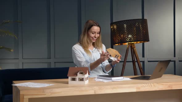 Young Female Architect Working on the New Desing of House Using 3d House Model. alt