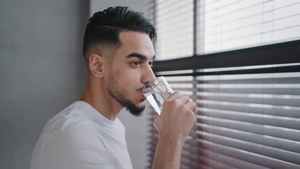 Hispanic Indian Arab Bearded Guy Millennial Man Looking Window at Home in Gym Drinks Clean Delicious alt