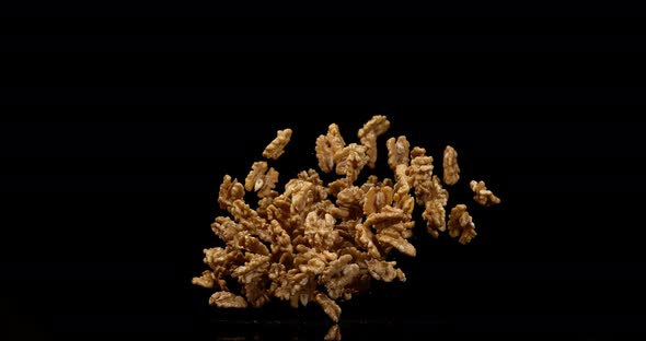 Walnut Kernels, juglans regia, Fruits falling against Black Background, Slow Motion 4K alt