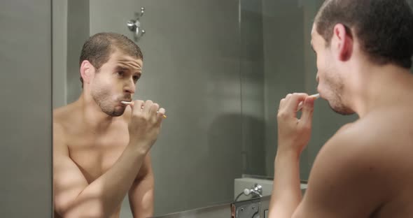 Attractive Young Man Brushing His Teeth Toothbrush in Bathroom