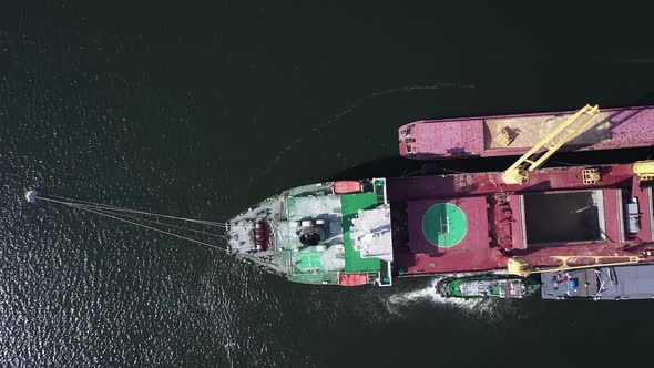 Top View of Cargo Bulker Lie on Anchor in with Barges on Both Sides of Vessel alt