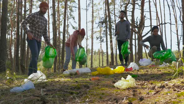 Group of Multi Ethnical Friends Cleaning Forest from Plastic Trash