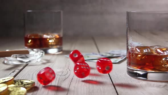 Two Glasses of Whiskey and Dice Fall on a Wooden Table