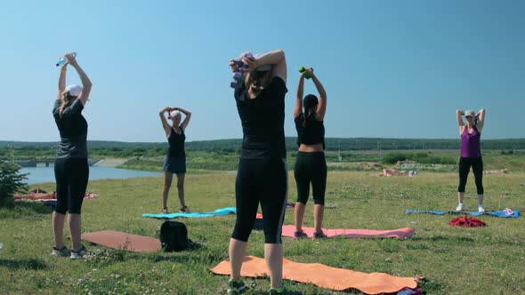 Group of women doing fitness exercises outdoors