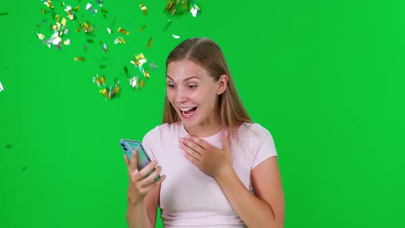 Young Woman Uses a Smartphone Looks at the Screen and Learns About the Win Young Woman Wins Golden alt