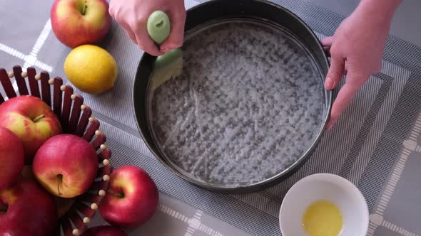 Apple Pie Preparation Series  Woman Greases the Baking Dish with Melted Butter alt