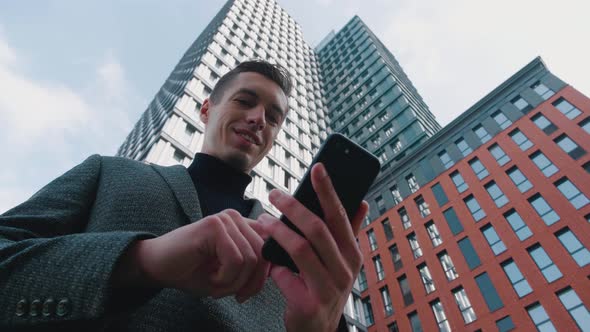 Man Using Business App on Smartphone on City Background alt