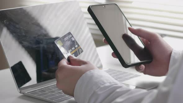 Asian businessman holding typing mobile phone and use credit card payment in a smartphone.