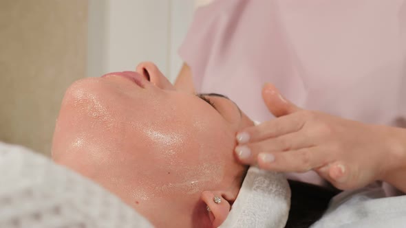 Wellness and Beauty Salon. Relaxed Woman Lying on Couch and Having Deep Cleansing Nourishing Facial alt