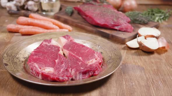 A Chunk of Raw Beef Ribeye Steak on an Aged Plate alt