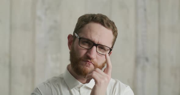 Serious Man with Glasses in Office Looking at Camera and Points His Finger