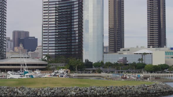 Boats anchored in front of modern buildings alt