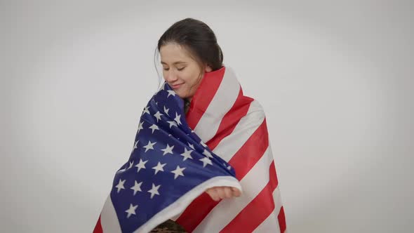 Happy Woman in Military Tshirt Wrapping in American Flag Smiling Looking at Camera alt