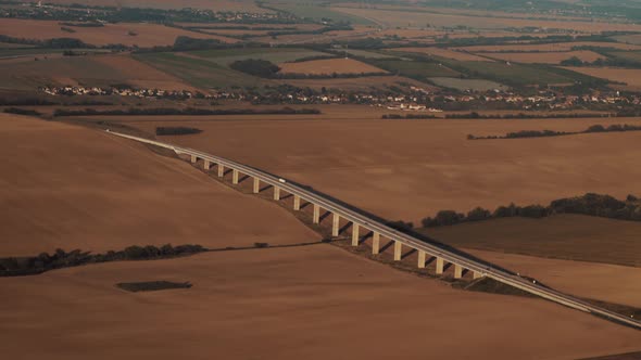 Aerial view of highway bridge in Countryside with orange fields alt
