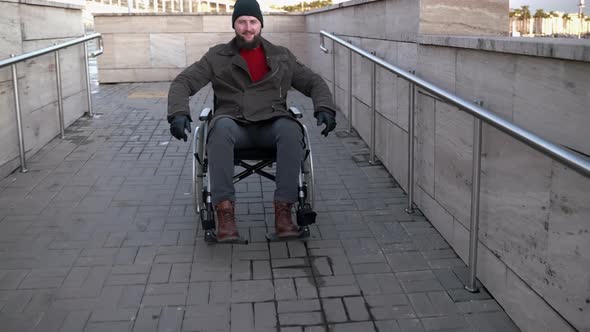 Cheerful Disabled Man Moving Down Wheelchair Ramp alt