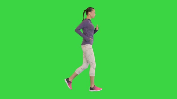 Female Runner in Sporty Outfit Jogging on a Green Screen Chroma Key
