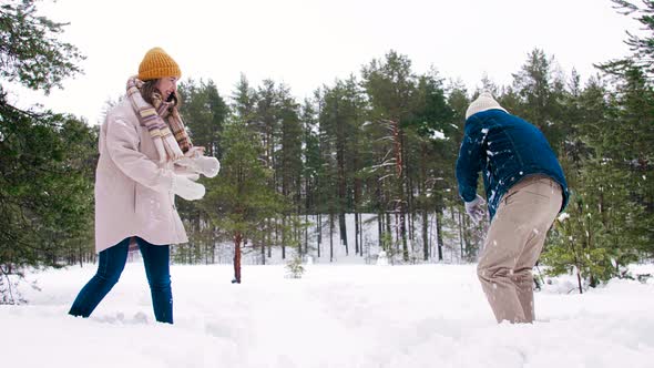 Happy Couple Playing Snowball Fight Game in Winter