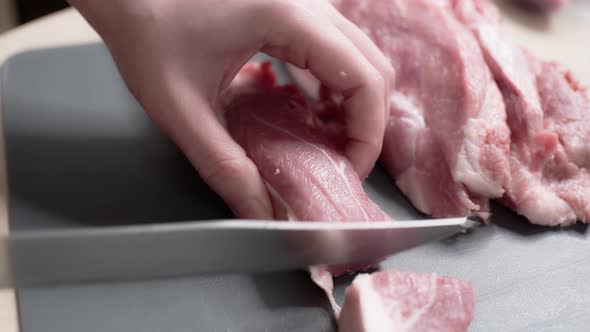 close-up of a hand with a knife and fresh meat