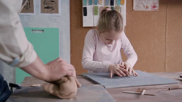 Little Girl with Manufacture Master Molding Clay in Small Worksh
