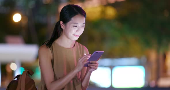Woman use of mobile phone in the city at night alt