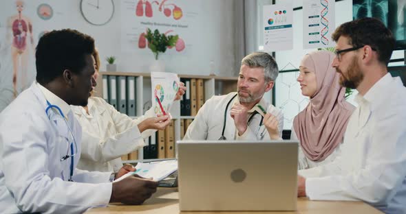 Medical Colleagues Discussing Results of Researches with Partners Via Video Chat on Laptop alt